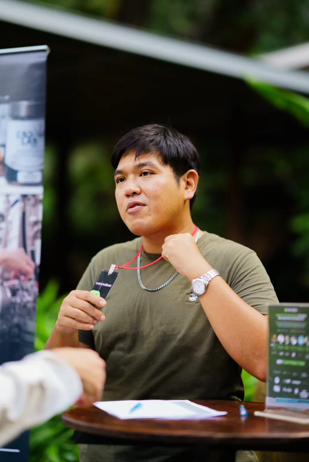 An event team member holds a microphone at an outdoor booth.