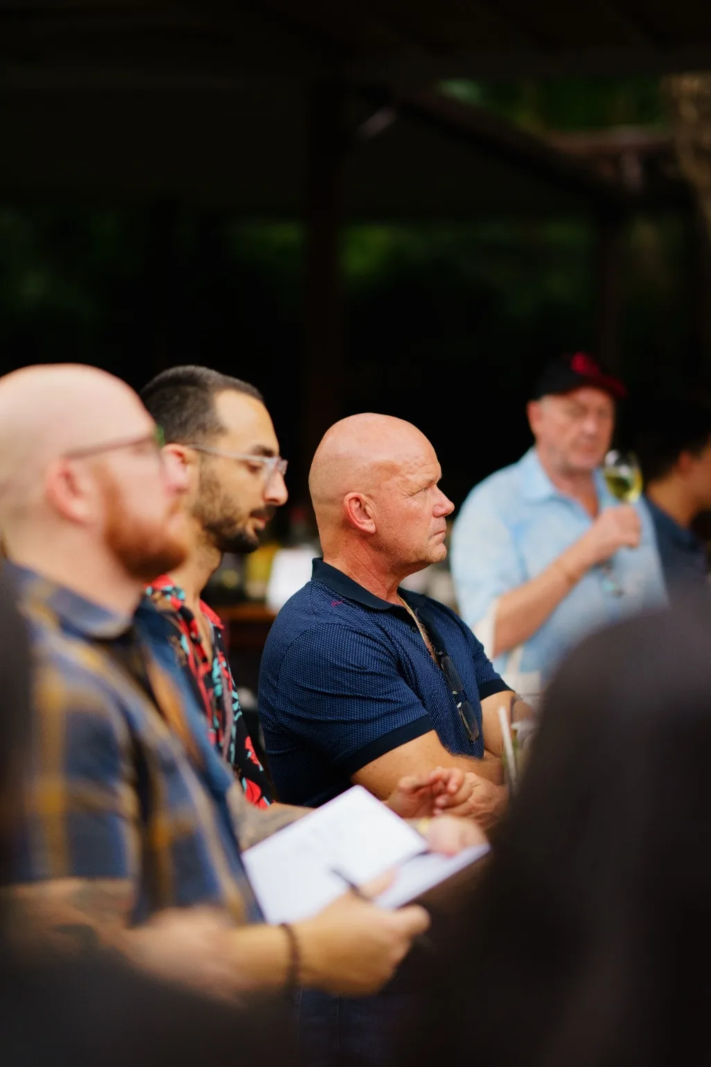 An attendee takes notes while standing with the workshop audience.