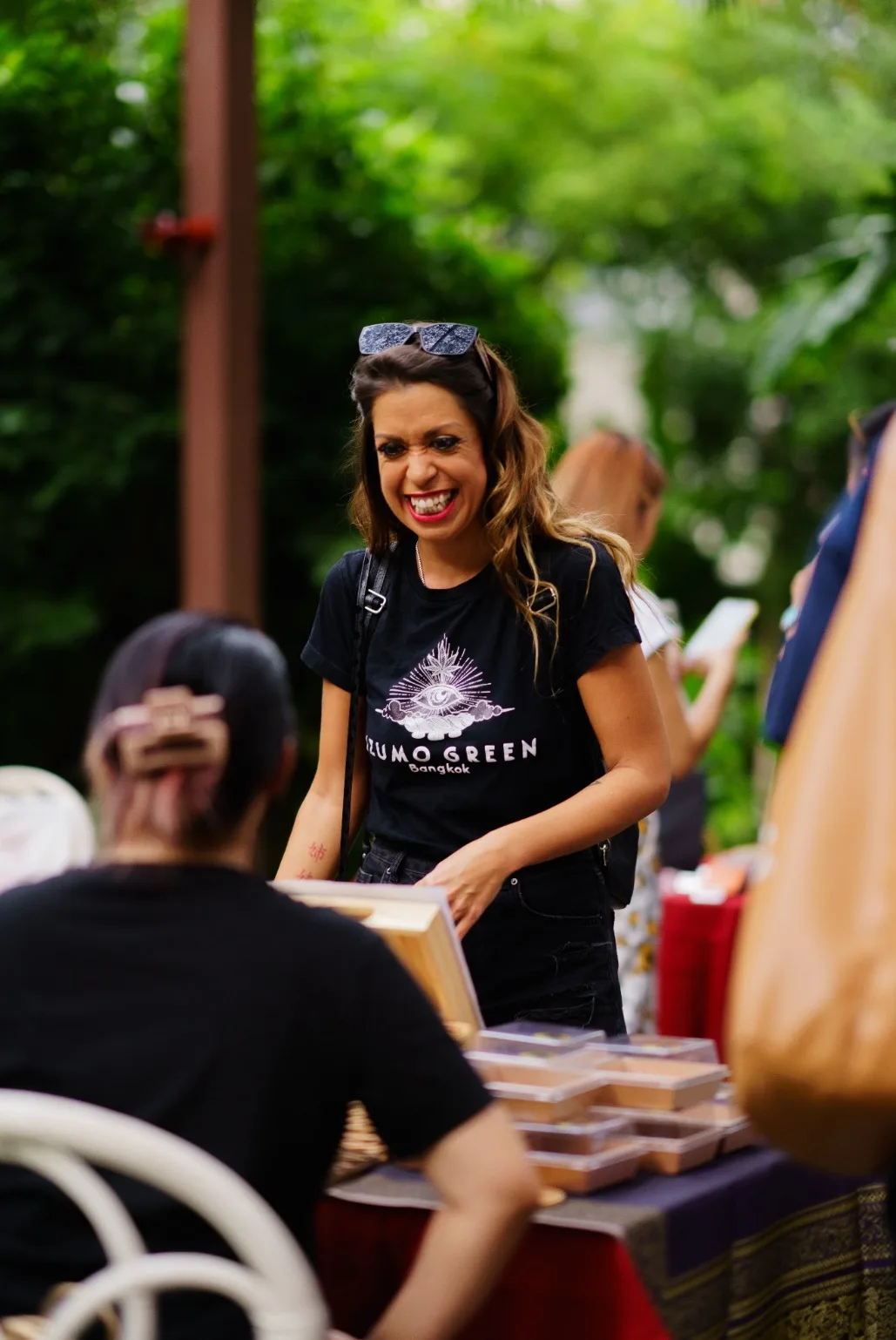 A sponsor representative smiles across a table of food samples.