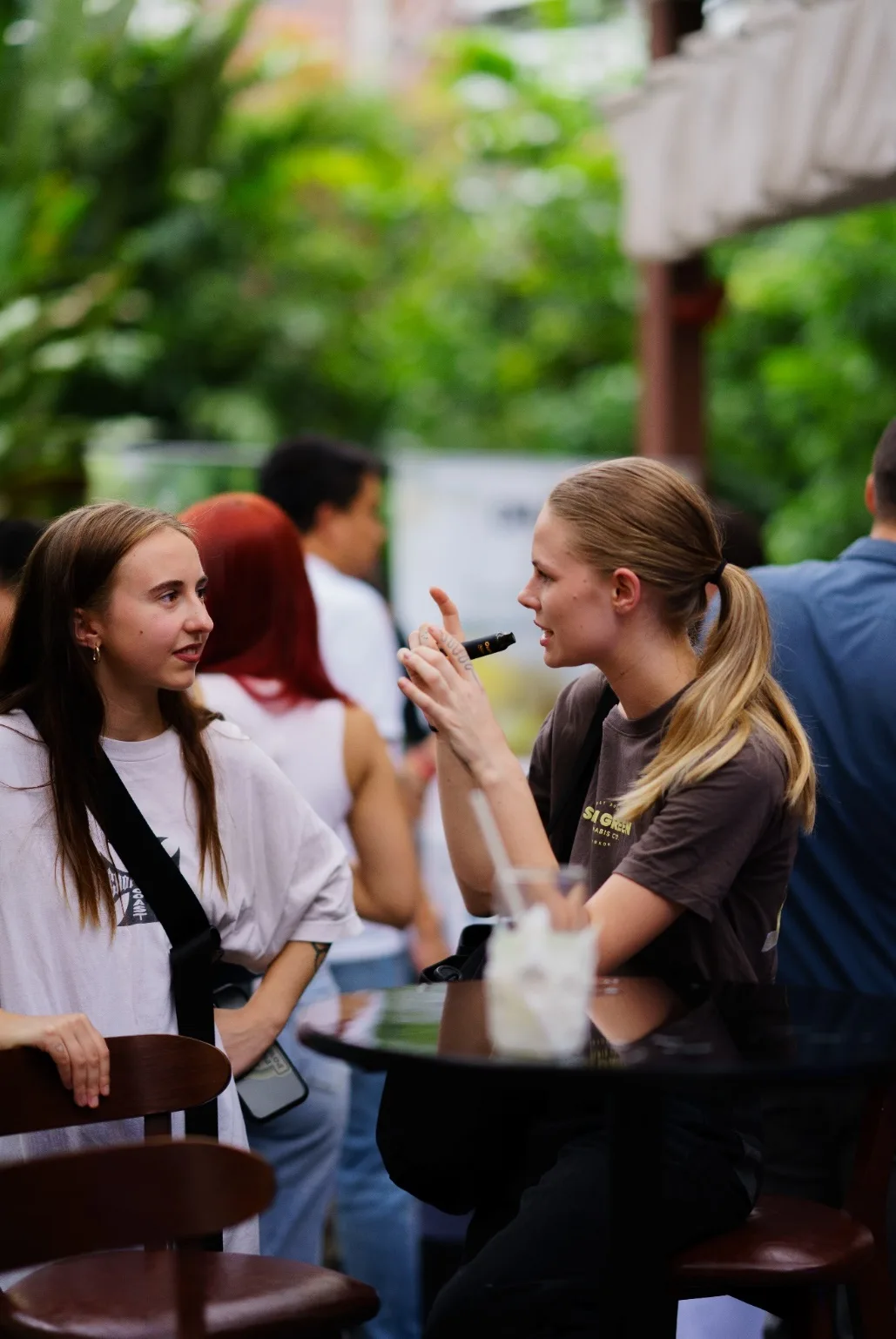 Two guests converse beside sponsor tables at MonkeyPod.