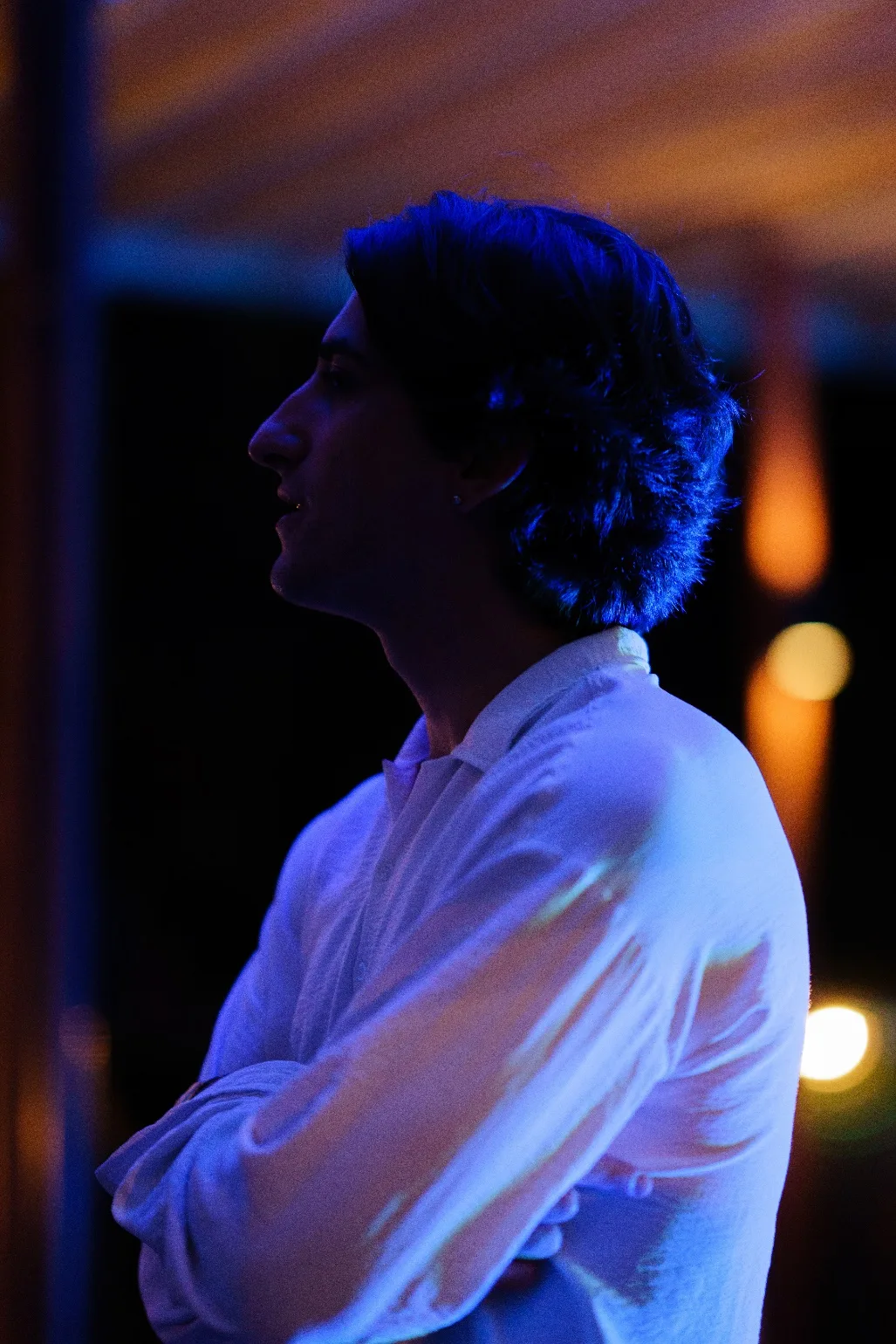 An attendee stands in blue light as night falls.